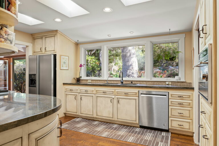 A kitchen with a stainless steel sink and counter tops.
