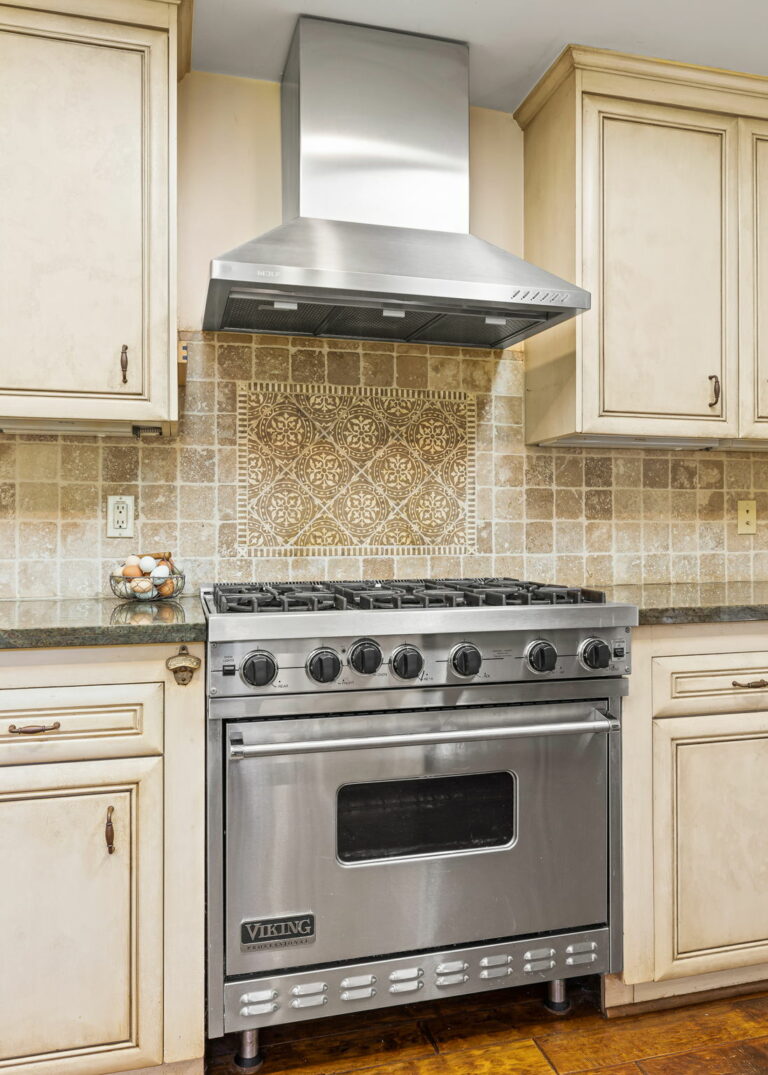 A kitchen with a stainless steel range hood.
