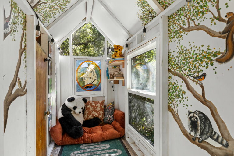 A tiny house with a panda stuffed animal in it.