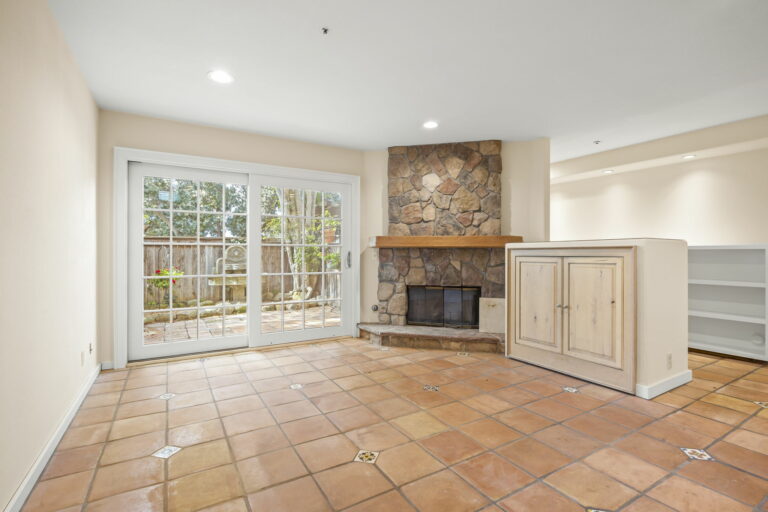 An empty room with tile floors and a fireplace.