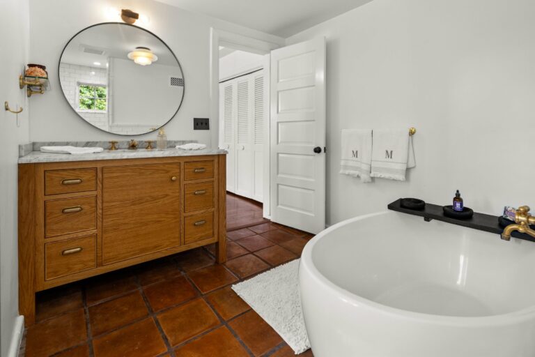 A bathroom with a bathtub and a large mirror.