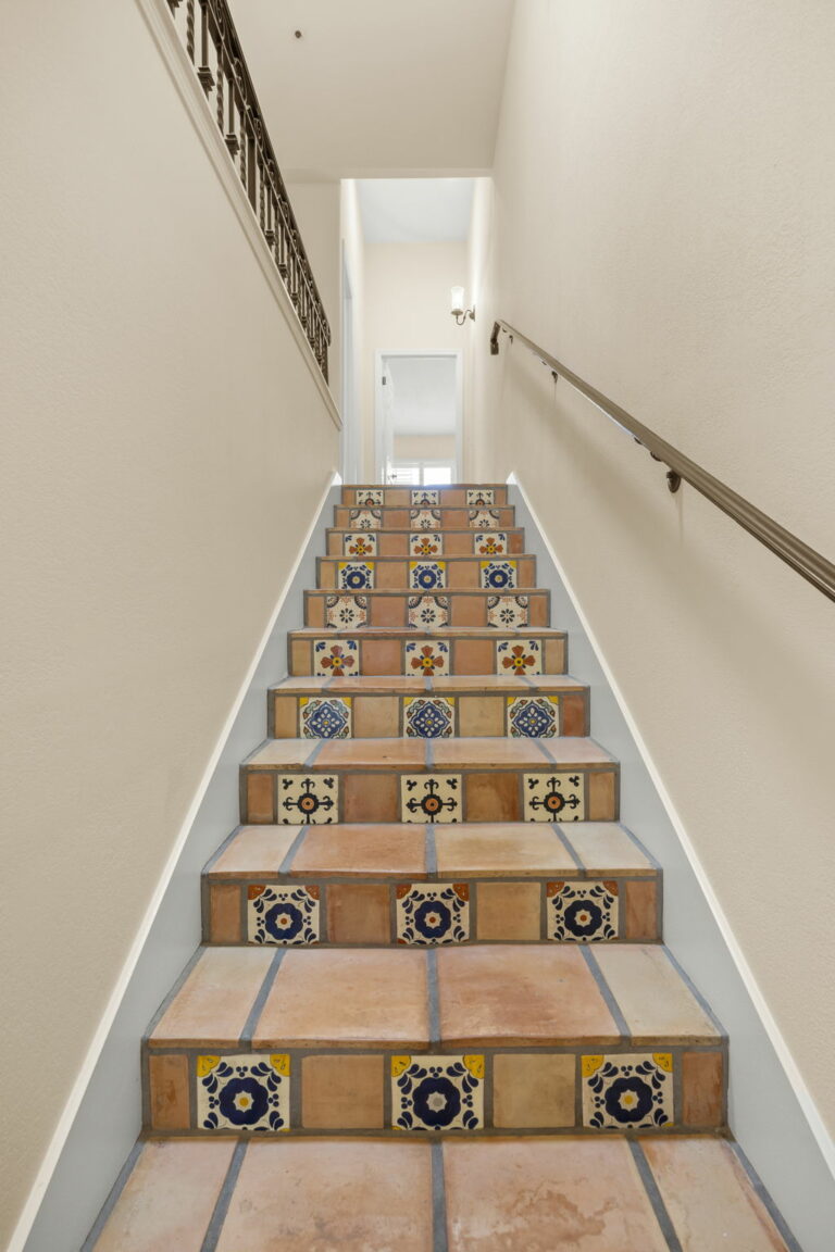 Tiled stairs in a house with a railing.
