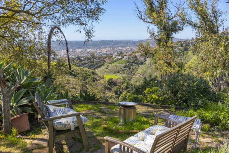 A patio with a view of the hills and trees.